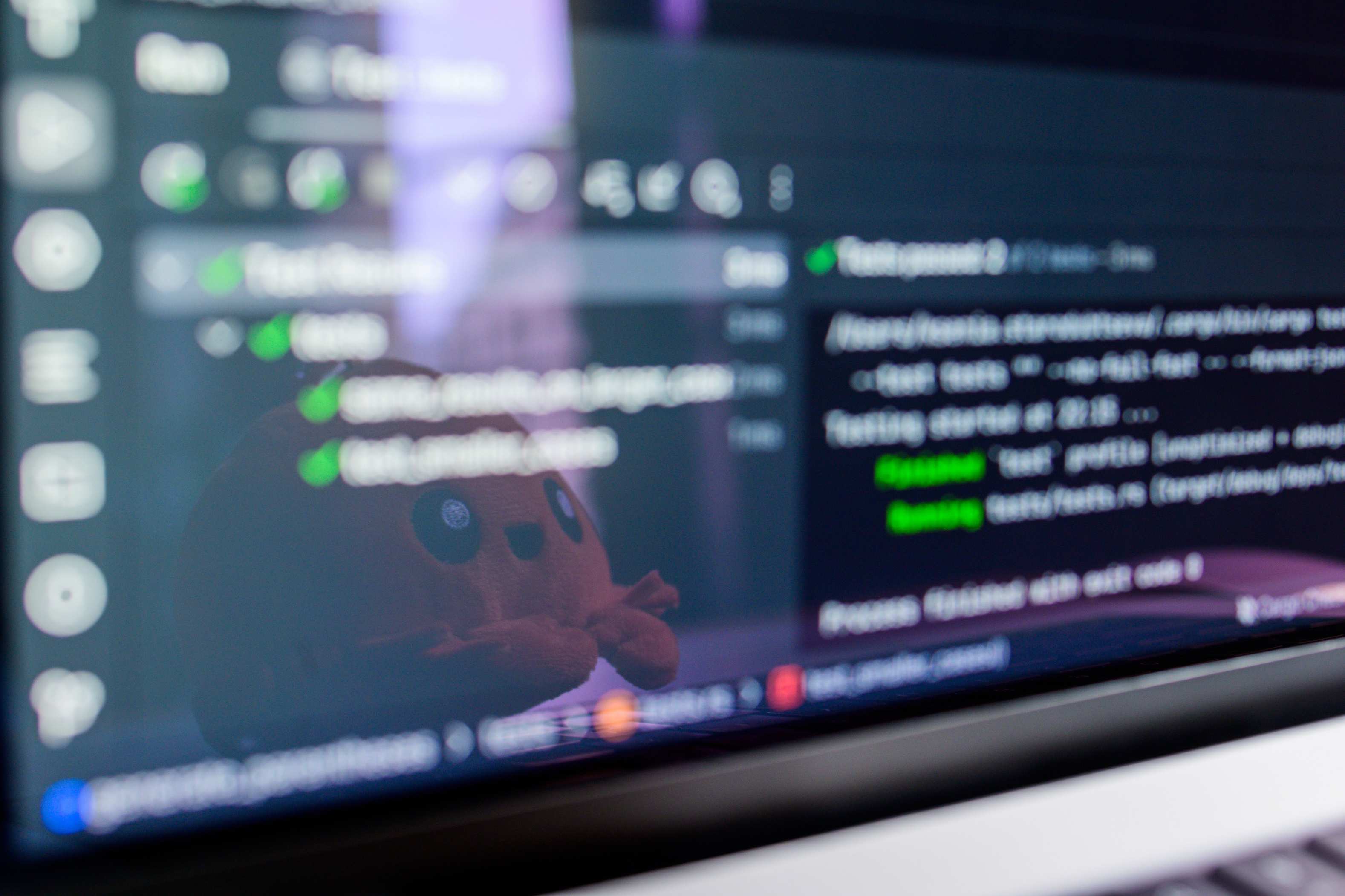 Developer workstation with laptop and monitors showing programming code